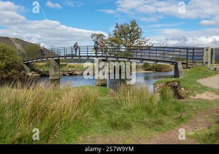 Les gens marchent les touristes marchant à travers Chinese Bridge près de Derwentwater dans le parc national du district des lacs d'automne Cumbria Angleterre Royaume-Uni Banque D'Images