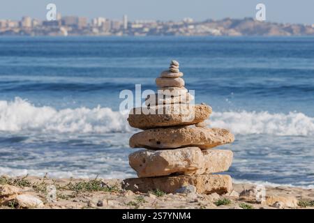 Pierres empilées sur la plage de chiens Agua Amarga à Alicante, Espagne Banque D'Images