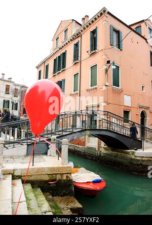 VENISE, ITALIE - 14 FÉVRIER 2015 : ballon rouge perdu lors de la fête du carnaval attaché à la rampe du canal. Banque D'Images