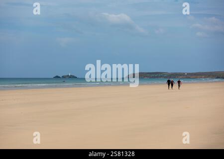 Les visiteurs apprécient une promenade paisible le long de la plage de sable de Gwithian à Cornwall, Angleterre, Royaume-Uni Banque D'Images
