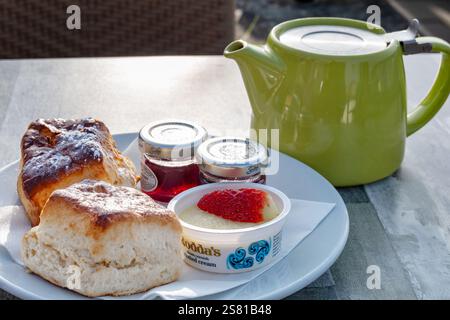 Clevedon, Royaume-Uni. Un thé traditionnel anglais à la crème servi à une table de café. Un pot de thé est servi avec des scones, de la crème épaisse et de la confiture de fraises. Banque D'Images