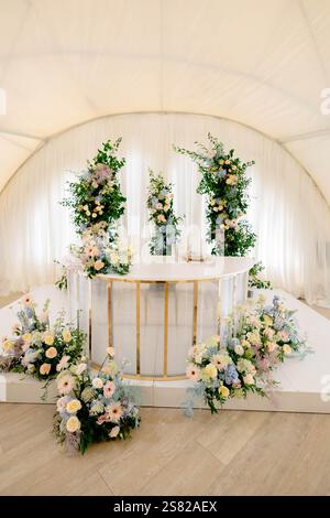 Table de Présidium décorée avec des fleurs de couleur pastel dans une tente de chapiteau de mariage crée une atmosphère romantique et élégante Banque D'Images