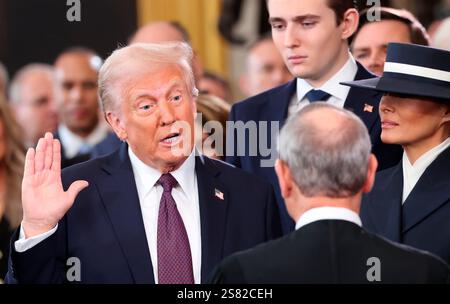 Le président américain Donald Trump prête serment alors que Barron Trump et Melania Trump regardent le jour de son investiture présidentielle à la rotonde du Capitole américain à Washington, États-Unis, le 20 janvier 2025. REUTERS/Kevin Lamarque/Pool Banque D'Images