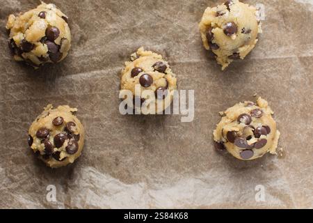 Vue de dessus de la pâte à biscuits aux pépites de chocolat en train d'être ramassée sur une plaque à pâtisserie, vue de dessus de la pâte à biscuits aux pépites de chocolat maison, processus de préparation de ch Banque D'Images