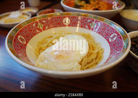Spaghetti avec oeuf frit sur une assiette dans un restaurant chinois. Banque D'Images