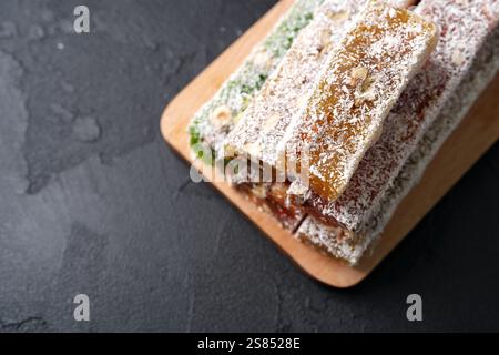 Délicieuses barres de noix et de fruits enrobées de noix de coco sur un plateau en bois présentant une option de collation saine Banque D'Images