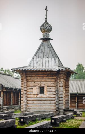 Chapelle en bois altérée debout haute avec un toit orné de croix, symbolisant l'héritage spirituel dans le paysage rustique du village russe Banque D'Images