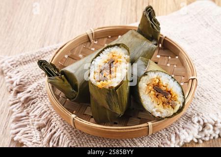 Arem-arem, un aliment traditionnel indonésien à base de riz fourré de légumes, de poulet, de viande ou de tempeh enveloppé dans des feuilles de bananier. Banque D'Images