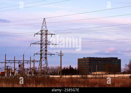 Tours de transport d'électricité à haute tension et infrastructure de sous-station mettant en valeur la distribution d'énergie sur fond de ciel couvert. Banque D'Images