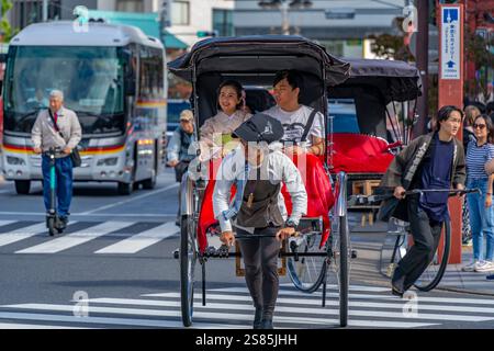 Vue de pousse-pousse japonais (jinrikisha) dans une scène de rue animée, Asakusa, Taito City, Tokyo, Honshu, Japon Banque D'Images