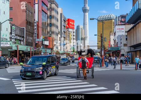Vue de pousse-pousse japonais ou jinrikisha dans la scène de rue animée, Asakusa, Taito City, Tokyo, Honshu, Japon Banque D'Images