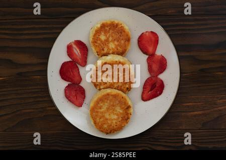 Syrniki maison avec des fraises sur table rustique Banque D'Images
