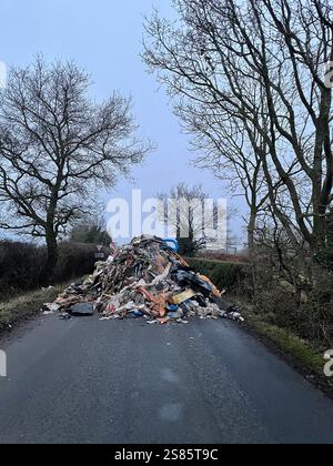 Le tas de déchets de 1 m de haut de Watery Lane, à la périphérie de Lichfield dans le Staffordshire. Les autorités locales recherchent des preuves vidéo pour retrouver les mouches qui ont déversé un énorme monticule de déchets de construction s'étendant sur plus de 40 pieds le long d'une route à deux voies, bloquant l'accès aux maisons et aux entreprises. Date de la photo : mardi 21 janvier 2025. Banque D'Images