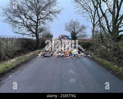 Le tas de déchets de 1 m de haut de Watery Lane, à la périphérie de Lichfield dans le Staffordshire. Les autorités locales recherchent des preuves vidéo pour retrouver les mouches qui ont déversé un énorme monticule de déchets de construction s'étendant sur plus de 40 pieds le long d'une route à deux voies, bloquant l'accès aux maisons et aux entreprises. Date de la photo : mardi 21 janvier 2025. Banque D'Images