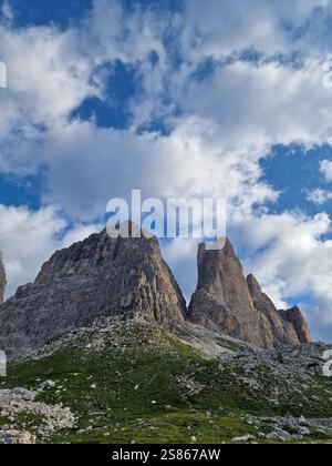 Vue imprenable sur les pics montagneux accidentés dans les Dolomites, les formes pointues et dentelées et les surfaces rocheuses, l'herbe verte luxuriante, les nuages moelleux, la randonnée à Tre Cime Banque D'Images