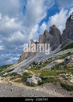 Vue imprenable sur les pics montagneux accidentés dans les Dolomites, les formes pointues et dentelées et les surfaces rocheuses, l'herbe verte luxuriante, les nuages moelleux, la randonnée à Tre Cime Banque D'Images