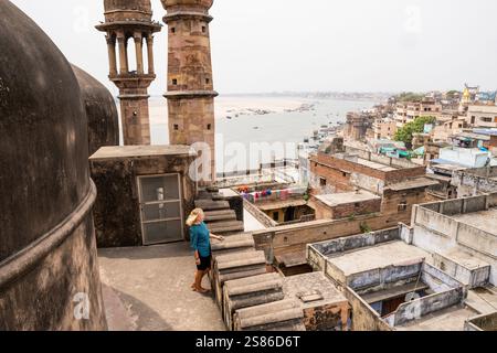 Jeune femme debout sur le toit de la mosquée surplombant la vieille ville de Varanasi et le fleuve Gange dans l'Uttar Pradesh, Inde. Banque D'Images