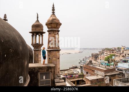 Jeune femme debout sur le toit de la mosquée surplombant la vieille ville de Varanasi et le fleuve Gange dans l'Uttar Pradesh, Inde. Banque D'Images