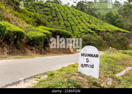 MUNNAR, INDE - 1er MAI 2024 : panneau routier sur la plantation de thé indiquant la distance à Munnar dans le Kerala, Inde. Banque D'Images
