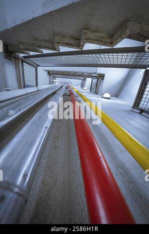 La photo intérieure montre des tuyaux colorés et des détails structuraux dans un bâtiment industriel en béton, parking ZOB de la société d'utilité publique Calw, Calw, Banque D'Images