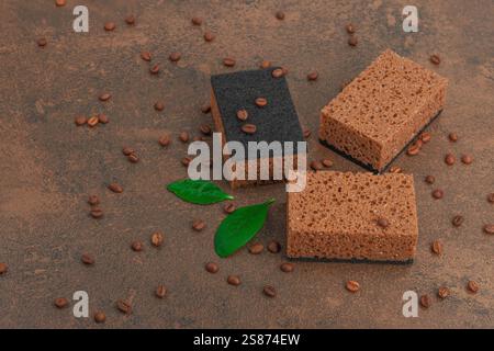 Ensemble d'éponges pour laver la vaisselle. Concept de nettoyage biologique, arôme de café. Style zéro déchet, fond de pierre marron chaud, pose plate, espace de copie Banque D'Images
