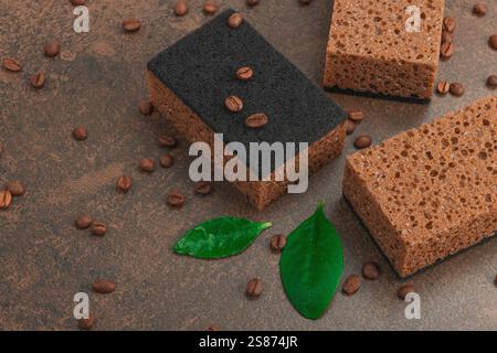 Ensemble d'éponges pour laver la vaisselle. Concept de nettoyage biologique, arôme de café. Style zéro déchet, fond de pierre marron chaud, pose plate, gros plan Banque D'Images