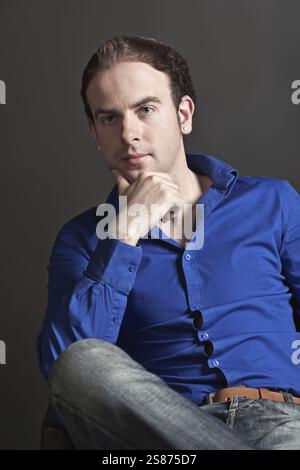 Portrait d'un jeune bel homme pensif touchant son menton, Belgique, Europe Banque D'Images