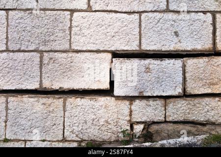 Un mur substantiel fait de blocs de pierre lourds, avec des joints fissurés maintenus avec du ciment de mortier, qui a bougé en raison de l'affaissement. Croatie. (138) Banque D'Images