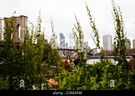 15 mai 2024 - New York, États-Unis : dame touristique posant pour la photo devant le pont de Brooklyn à New York Banque D'Images