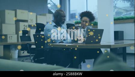 Image de taches jaunes brillantes sur divers hommes d'affaires au bureau Banque D'Images