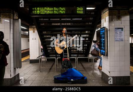 New York, États-Unis - 17 mai 2024 : musicien de rue, jouant de la guitare dans la station de métro de Manhattan, États-Unis Banque D'Images