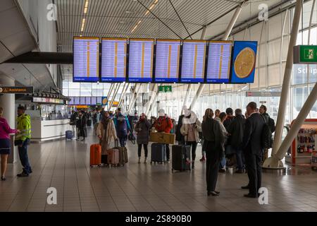 Touristes et passagers marchent avec leurs bagages à la porte de leur avion à l'aéroport de Schiphol à Amsterdam. Banque D'Images