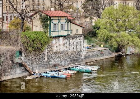 Plusieurs petits bateaux sont amarrés sur un quai le long de la rive de la rivière Vltava Banque D'Images