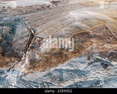 Vue aérienne de la glace et du champ d'un agriculteur à Urriðafoss, une cascade dans le sud de l'Islande Banque D'Images