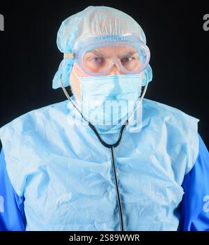 Gros plan portrait d'un médecin masculin sérieux en uniforme, bonnet chirurgical, masque médical et lunettes. Concept de santé, médecine et personnel médical. Docteur Man Banque D'Images