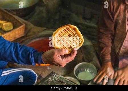 Sokalipura, Srinagar, Jammu-et-Cachemire, Inde. Homme tenant du pain plat. Banque D'Images