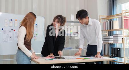 Équipe collaborative UX UI discutant des esquisses et des stratégies de conception dans un environnement de bureau moderne et lumineux Banque D'Images