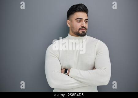 Portrait d'un homme d'âge moyen élégant posé sur fond gris Banque D'Images