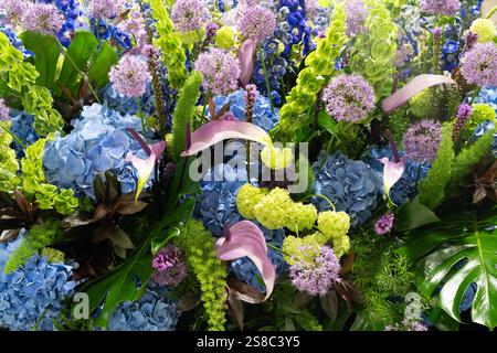 Un décor floral vibrant avec hortensias bleues et feuilles vertes disposées artistiquement Banque D'Images