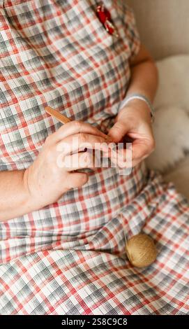Vue rapprochée des mains d'une femme âgée crochetant. Banque D'Images