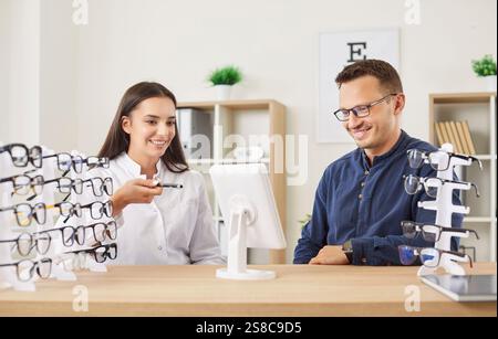 Jeune opticien aidant l'homme patient à choisir de nouvelles lunettes en clinique ophtalmologique Banque D'Images