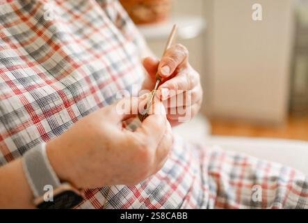 Vue rapprochée des mains d'une femme âgée crochetant. Banque D'Images