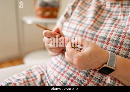 Vue rapprochée des mains d'une femme âgée crochetant. Banque D'Images
