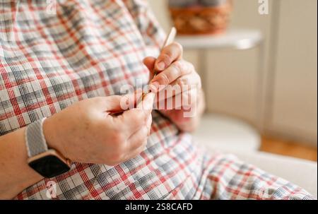 Vue rapprochée des mains d'une femme âgée crochetant. Banque D'Images