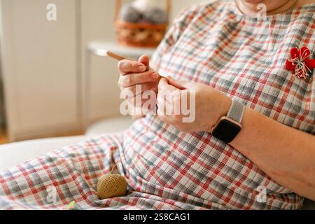 Vue rapprochée des mains d'une femme âgée crochetant. Banque D'Images