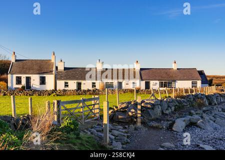 Rangée de cottages blancs pittoresques à côté d'Anglesey Coastal Path autour d'une petite baie sur la côte nord-est de l'île. Moelfre, Île d'Anglesey, Nord du pays de Galles Banque D'Images