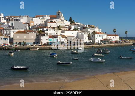 FERRAGUDO, PORTUGAL - 29 JUIN 2022 : vue sur le port de Ferragudo au coucher du soleil avec ses façades blanches typiques des maisons et l'église, Algarve regi Banque D'Images