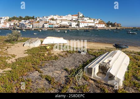 FERRAGUDO, PORTUGAL - 29 JUIN 2022 : vue sur le port de Ferragudo au coucher du soleil avec ses façades blanches typiques des maisons et l'église, Algarve regi Banque D'Images