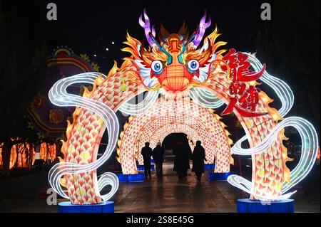 Pékin, Chine. 22 janvier 2025. Les touristes marchent à travers une lanterne en forme de dragon au Longting Park à Kaifeng, dans la province du Henan, en Chine centrale, le 22 janvier 2025. Alors que le nouvel an chinois 2025 tombera le 29 janvier, l’excitation est palpable partout en Chine. Les Chinois se plongent dans les coutumes traditionnelles et participent aux festivités. Le nouvel an chinois, ou la fête du printemps, tombe mercredi prochain, marquant le début de l'année du serpent. Crédit : Li Junsheng/Xinhua/Alamy Live News Banque D'Images