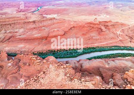 Prise de vue aérienne capture le serpentin Rio San Juan coupant à travers le paysage désertique rouge vif de l'Utah, entouré d'un terrain accidenté et d'un gre clairsemé Banque D'Images